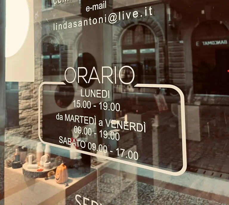 Vetrina del centro Mas Linda Beauty Lab di Rovereto con gli orari di apertura